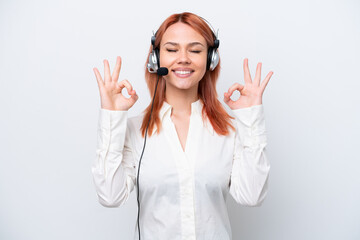 Telemarketer Russian girl working with a headset isolated on white background in zen pose