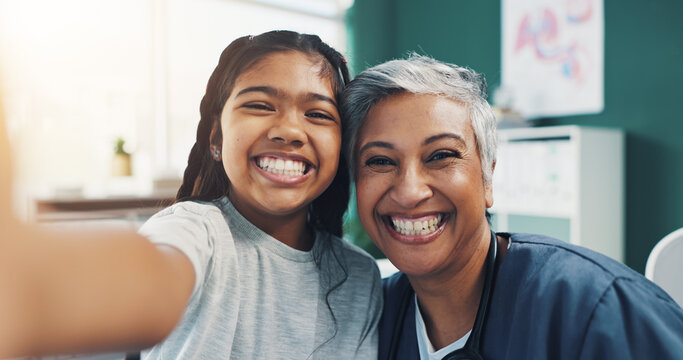 Mature woman, doctor and selfie with girl as patient with smile at clinic for social media and profile picture. People, pediatrician and happy with kid on portrait, confidence or pride for healthcare