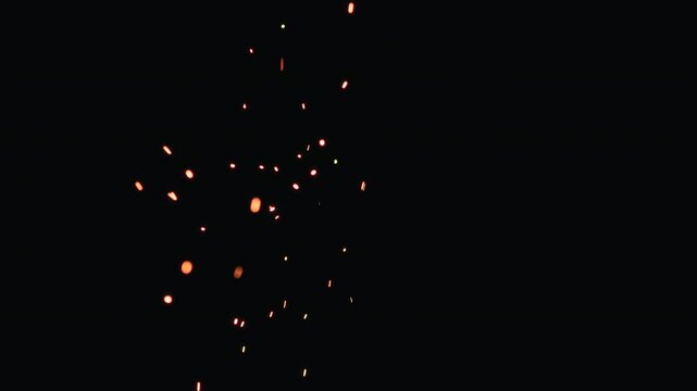 Slow motion hot sparks slowly falling from above black background, 60fps