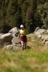 Obraz premium A woman is running in a field with a hat on