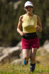 Fototapeta premium A woman is running in a field wearing a yellow shirt and red shorts