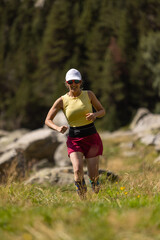 Fototapeta premium A woman is running in a field with a hat on