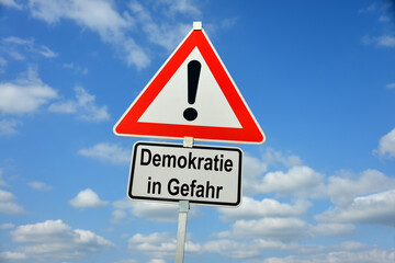 Burgdorf, Lower Saxony, Germany - January 16, 2024: Traffic warning sign saying Democracy in danger (in German Demokratie in Gefahr)