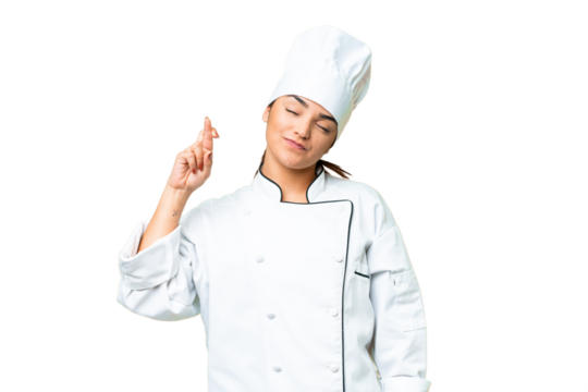 Young woman Chef over isolated chroma key background with fingers crossing and wishing the best