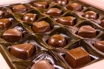 Heap of chocolate candies in a brown box