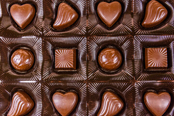Heap of chocolate candies in a brown box. Top view