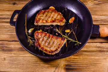 Roasted steaks with garlic, rosemary and spices in a cast iron grill pan