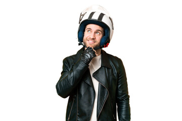 Young handsome blonde man with a motorcycle helmet over isolated chroma key background and looking up