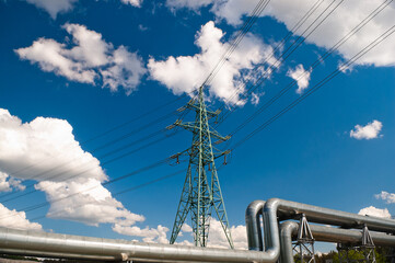 pipeline and power lines, blue sky and clouds in the background