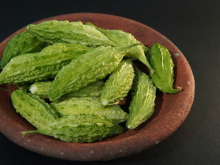 Momordica charantia fruit or (Peria, Bitter Gourd, Bitter Melon, Bitter Cucumber, Balsam Pear, Leprosy Gourd, Pare) on a black background