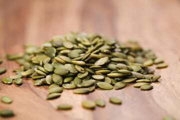 green pumkin seeds on wooden table