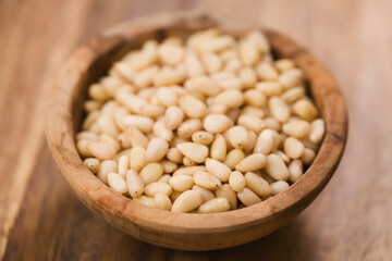 pine nuts in wood bowl on table