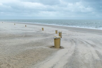 yellow garbage cans on the beach, north sea, Netherlands