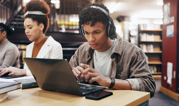 Man, studying or laptop in library with headphones, problem solving or working on research assignment. Student group, concentration music or tech at college for education, online course or learning