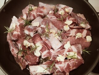 mixed pork meat cooked in a pan with rosemary and sage, butter, oil and salt