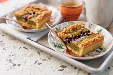 dessert and coffee for two. nut cake with pieces of pistachios and coffee on the table in an open-air cafe.