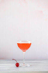 Cocktail glass with red drink standing on white table