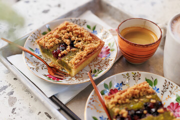 dessert and coffee for two. nut cake with pieces of pistachios and coffee on the table in an open-air cafe.