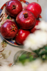 pomegranates on the table. Beautifully decorated table with a plate of pomegranates.