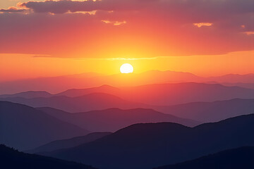 Obraz premium Vibrant sunset over layered, misty mountains.