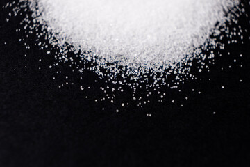 Macro crystals of white rock edible salt on black background space for text
