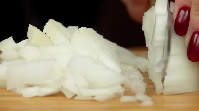 Close up view The knife cuts the onion into small square pieces. High quality 4k footage