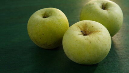 green apple fruit on a green wooden board. healthy food theme, healthy lifestyle theme
