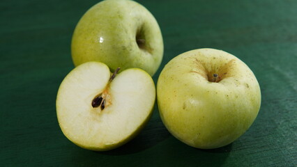 green apple on a green wooden board. healthy food theme, healthy lifestyle theme