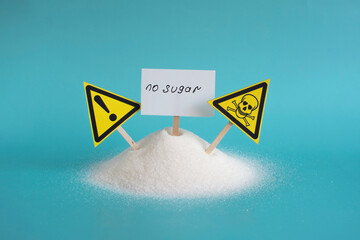 Warning about the dangers of sugar on the background of a mountain of granulated sugar and yellow...