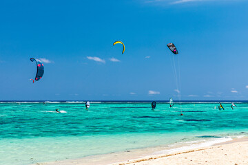 Kite surfers in the waters of Indian Ocean, Mauritius. Kite surfing in the clear waters of the...