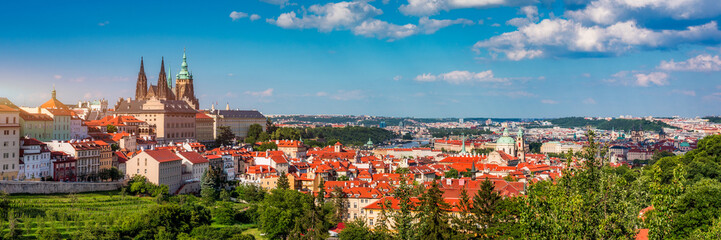 View of Prague featuring historic castle and vibrant rooftops on a sunny day in summer. Aerial view of Prague, Charles Bridge over Vltava river in Prague, Czechia. Old Town of Prague, Czech Republic.