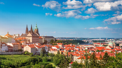 View of Prague featuring historic castle and vibrant rooftops on a sunny day in summer. Aerial view...