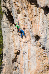 A rock climber ascends to the summit via a difficult route.