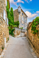 Charming street in quaint Menerbes village with colorful buildings and vibrant flowers. Village of Menerbes (Most Beautiful Village in France) in the Luberon mountains, France, Luberon, Vaucluse.