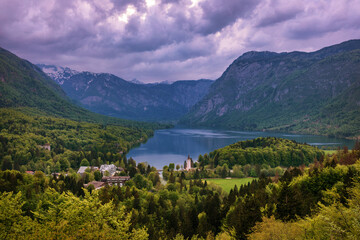 Aerial view of Bohinj lake in Julian Alps. Breathtaking view of the famous Bohinj lake from above. Beautiful view of the Triglav national park and the church of St John the Baptist. Slovenia, Europe