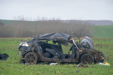 Voiture noire accidentée et complètement détruite dans un champ, après avoir effectué...