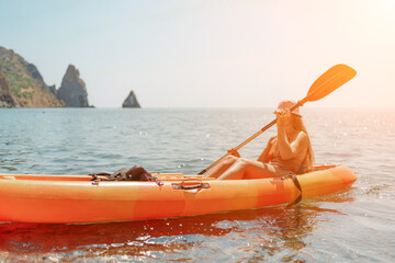 Kayak sea woman. Happy attractive woman with long hair in red swimsuit, swimming on kayak. Summer holiday vacation and travel concept.