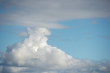 Obraz premium Gros plan sur des nuages gris et blancs avec des morceaux de ciel bleu 