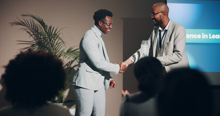 Handshake, award and smile of men, seminar and congratulations for success, event or corporate. Thank you, professional and celebration of hard work, winning and holding hands for conference or prize