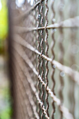 Close-up of a metal grid on a textured concrete surface. Geometric pattern with squares and rough texture