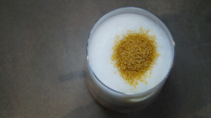 brown cane sugar on white foam in a glass