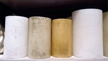 New wax candles on the shelf in the home decor store. Decorative white and gold candles. Home decor. New Year and Christmas candles. Handmade.