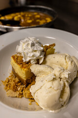 Cheese cake, bananas, caramel dessert. Making dessert behind the scenes. Vanilla Ice cream, whip cream topped on cheese cake, banana sauce topping with caramel on top. 