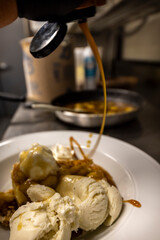 Cheese cake, bananas, caramel dessert. Making dessert behind the scenes. Vanilla Ice cream, whip cream topped on cheese cake, banana sauce topping with caramel on top. 