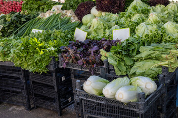 Fresh vegetables at a bustling local market showcasing a variety of greens and herbs