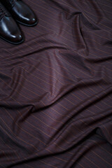 Obraz premium Male classic formal brown leather shoes on brown fabric suit background. Only toes visible. Copy space for logo design, advertising. Natural leather accessories for men
