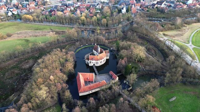 Smooth backward camera movement pulling away from a medieval castle and revealing the surrounding landscape in a cinematic wide view.