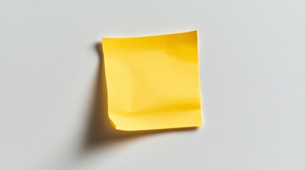 Yellow sticky note on a light gray background, ideal for reminder or message concepts in office and stationery themes.