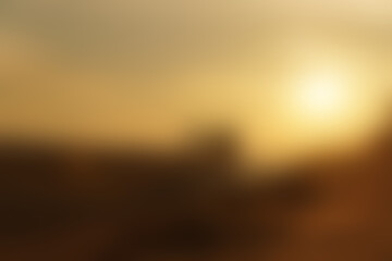 Blurred image of the morning or evening sunlight on a golden sky, representing tranquility and nature