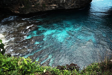 Beautiful wave crashing rocky cliff and stone mountain at the blue calm sea on summer ocean on broken beach in Bali island at Indonesia